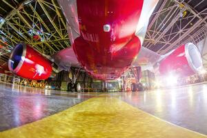 DIMEX | Vliesová fototapeta Letadlo v hangáru MS-5-2700 | 375 x 250 cm | červená, bílá, žlutá