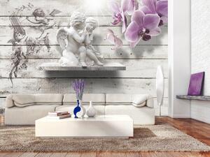 Fototapeta Polibek Kupida - socha páru andělů na pozadí šedého dřeva s orchidejí