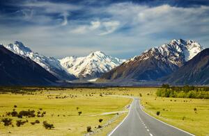 Fototapeta Nový Zéland - krajina zasněžených hor s zelenými poli a cestou