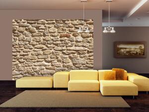 Fototapeta Stará kamenná zeď - vzor v kamenné zdi v pískové barvě