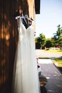 Umělecká fotografie Beautiful white wedding dress hanging elegantly, Wirestock, (26.7 x 40 cm)