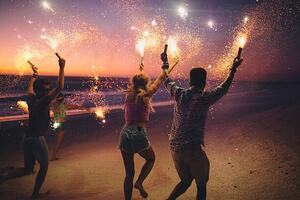 Umělecká fotografie Friends running on a beach with fireworks, wundervisuals, (40 x 26.7 cm)