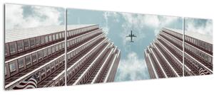 Obraz letadla mezi budovami (170x50 cm)