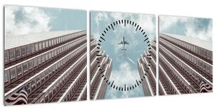 Obraz letadla mezi budovami (s hodinami) (90x30 cm)