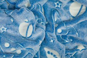 Dětská mikroplyšová deka Vesmír modrý, která ve tmě svítí. Rozměr deky je 150x100 cm