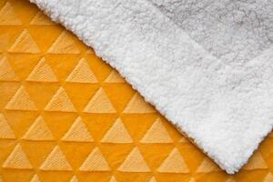 Měkoučká beránková deka ve zlaté barvě s jemným vzorem trojúhelníků. Imitace ovčí vlny, velmi příjemná na dotek, nekouše. Rozměr 150x200 cm