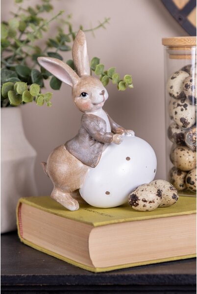 Velikonoční figurka hnědý zajíček se opírá o bílá zdobené vajíčko Brulstijn – 17 cm