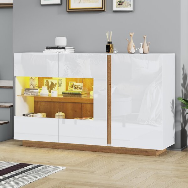 Bílá komoda s lesklým povrchem, vyrobená z laminované dřevotřísky s prosklenými prvky, s dřevěnou podnoží, moderní design