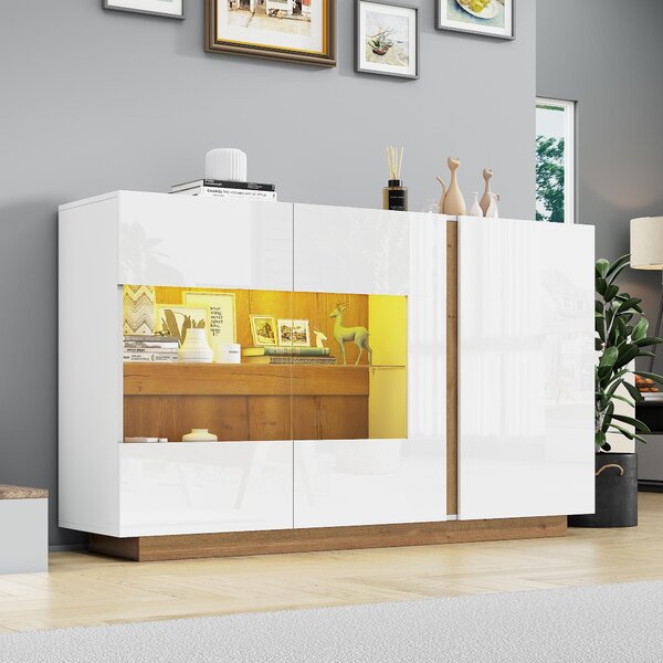 Bílá komoda s lesklým povrchem, vyrobená z laminované dřevotřísky s prosklenými prvky, s dřevěnou podnoží, moderní design