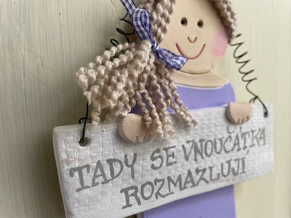 Babička v fialových šatech Nápis: Tady se vnoučátka rozmazlují
