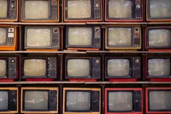 DIMEX | Vliesová fototapeta Zeď starých televizorů MS-5-2161 | 375 x 250 cm| červená, černá, žlutá, oranžová, šedá