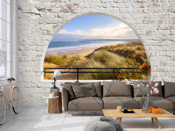 Fototapeta Výhled z okna - krajina s mořem a písčitou pláží obklopenou zdivem