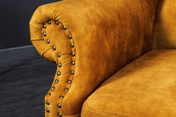 Chesterfield křeslo Cella se sametovým čalouněním v hořčicově žluté barvě s tmavě hnědými masivními nožičkami 105cm