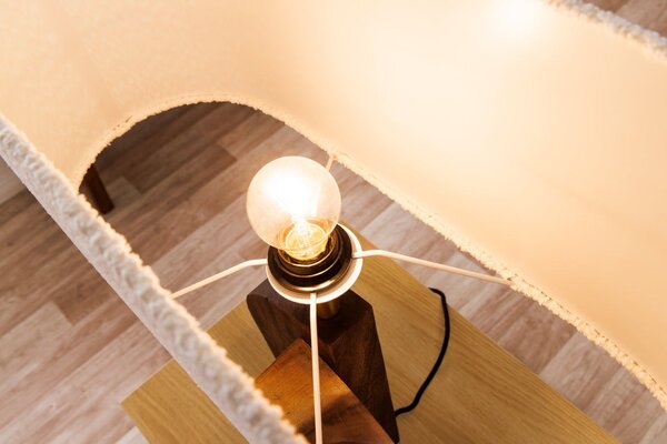 Designová venkovská stolní lampa Amanti s asymetrickou podstavou z masivního dřeva a bílým buklé stínítkem 61 cm
