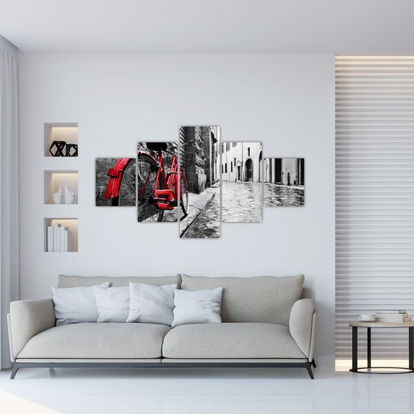 Obraz červeného kola na dlážděné ulici (125x70 cm)