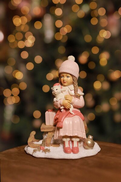 Růžová vánoční figurka holčička na sáňkách 16cm